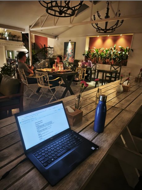 Digital nomad working on a laptop with coffee at Nomad Basecamp Pokhara